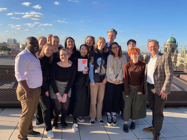 Gruppenfoto der Studierenden zusammen mit Prof. Dr. Christoph Zuschlag und Dr. Ohiniko Toffa auf der Dachterasse des Humboldt Forums.